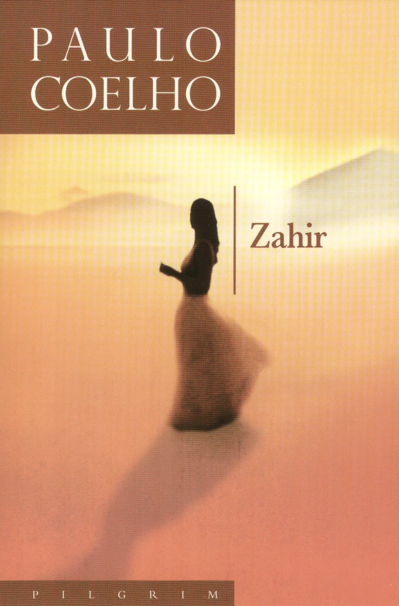 Zahir - Paulo Coelho (Pilgrim, 2005). Soojades kollakaspunastes toonides liivane maastik, mille keskel seisab kaugusse vaatav naisefiguur valgetes riietes. Atmosfääriline ja unenäoline meeleolu rõhutab kõrbe- või stepikeskkonda.