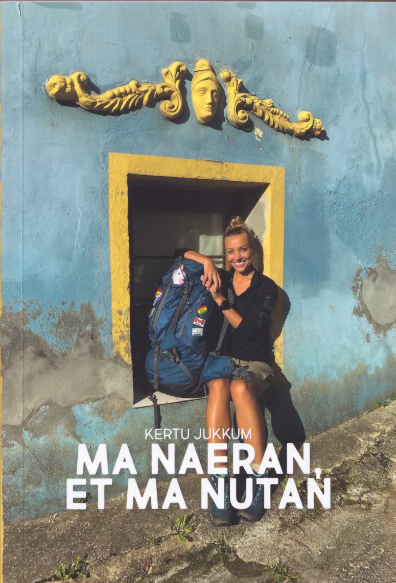 Ma naeran, et ma nutan - Kertu Jukkum (Rahva Raamat, 2020). Kaanel on foto naeratavast naisest, kes istub suure seljakotiga koloniaalses kollase ja sinise värviga ukseraami ees. Taust on kulunud helesinine müür kuldse kaunistusega.