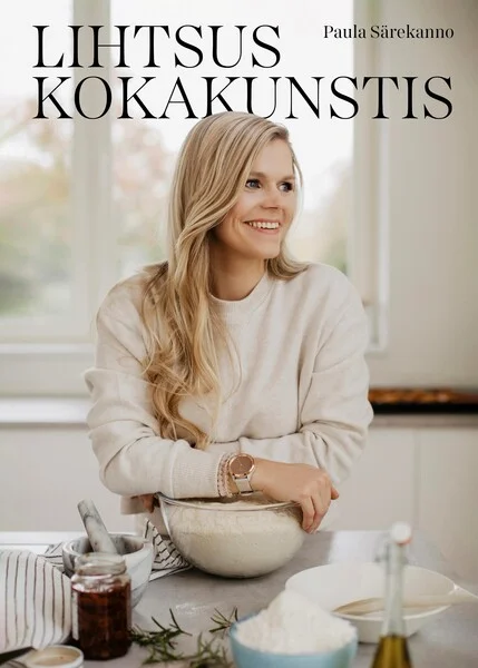 Lihtsus kokakunstis - Paula Särekanno (Ruubik Foods, 2022). Hele, sooja tooniga foto naisest, kes seisab köögilaual segamisnõu juures, ümbritsetuna toiduvalmistamise tarvikutest. Naine kannab valget riietust ning taust on õrnas, loomulikus valguses köögikeskkond.