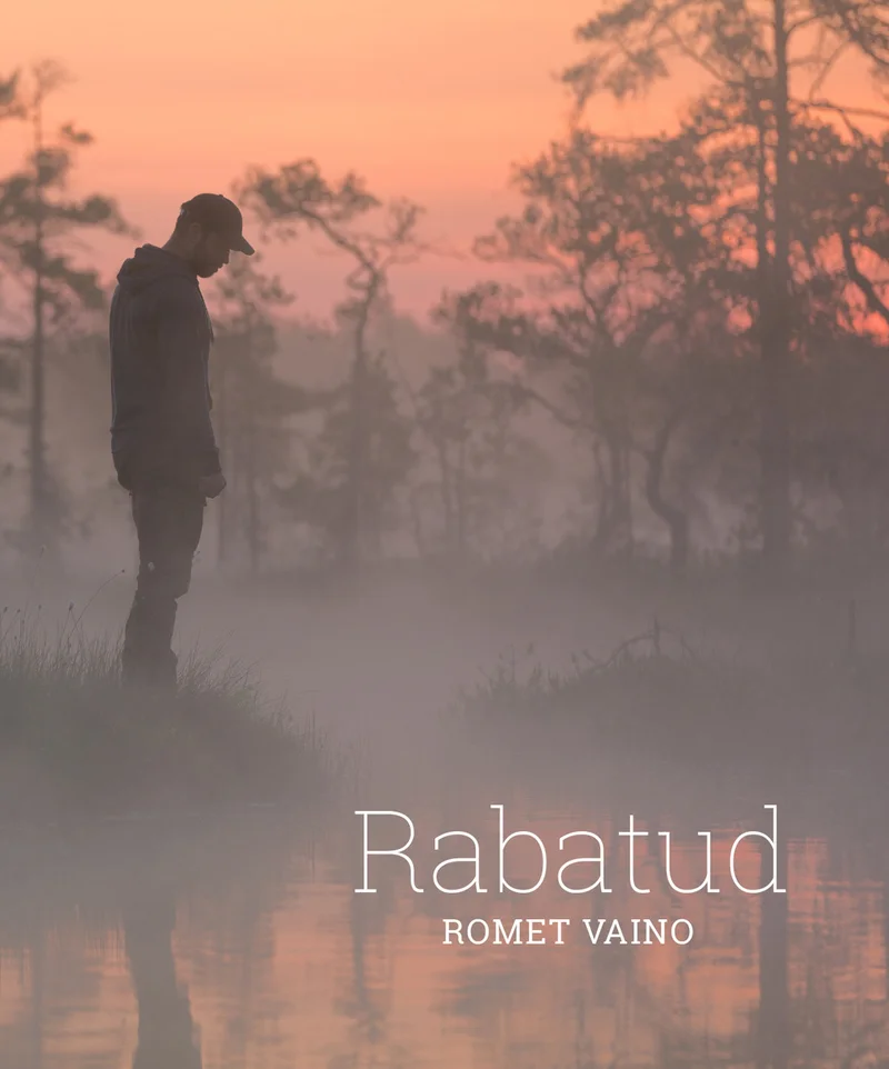 Rabatud - Romet Vaino (Helios, 2023). Hämaras roosa-oranži õhtuvalguses seisab mehe siluett uduses rabas, ümbritsetuna kõhnade puude ja veepeegli poolt.