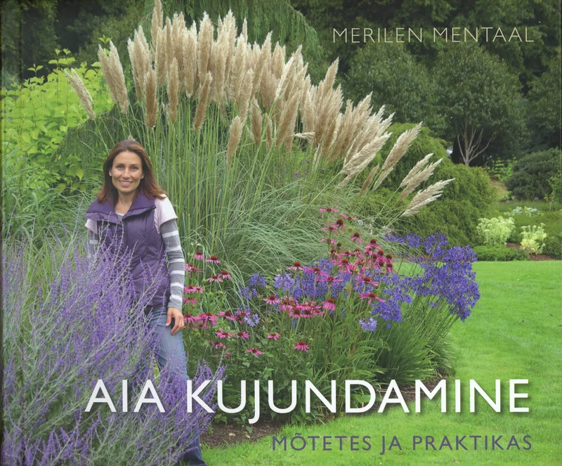 Aia kujundamine mõtetes ja praktikas - Merilen Mentaal (Varrak, 2024). Naine seisab lopsakas aias, mida ümbritsevad kõrged rohelised ja lillad taimed, sealhulgas dekoratiivhein ja õitsevad lillepeenrad. Fotol domineerivad rohelised ja lilla toonid, luues loomuliku ning maalilise aia atmosfääri.