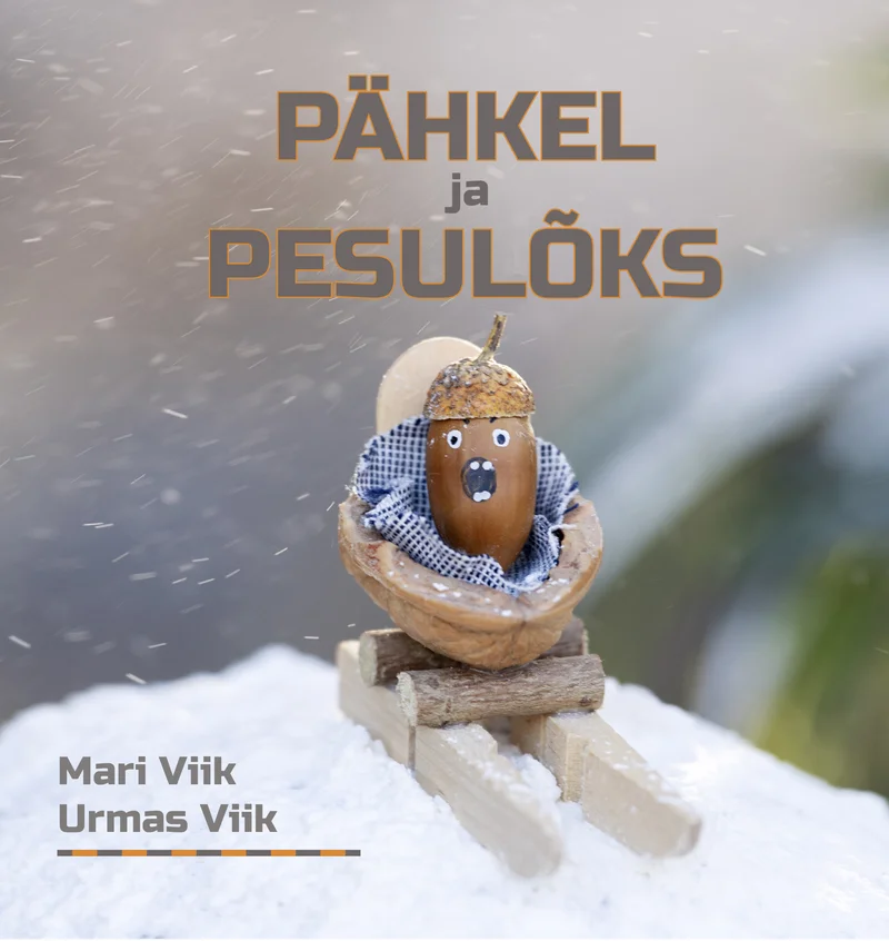 Pähkel ja pesulõks - Urmas Viik, Mari Viik (Postimees, 2024). Lumises talvises õhkkonnas istub väike käsitööfiguur — tammetõrust tehtud näoga tegelane, kes sõidab pesulõksust valmistatud kelgul. Figuuril on sinine sall kaelas ja pruun müts peas.