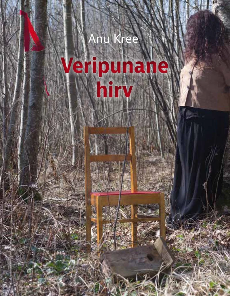 Veripunane hirv - Anu Kree (Emakeele Sihtasutus, 2026). Fotorealistlik kaanepilt, millel seisab naine tagasi pööratud näoga hõreda lehtmetsa serval ning tema ees on tühi puidust tool. Ülemises nurgas on väike punane lint või sümbol.