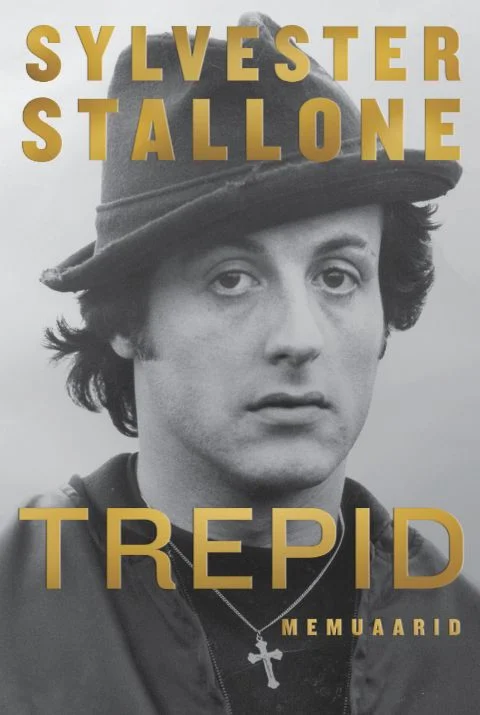 Trepid - Sylvester Stallone (Tänapäev, 2026). Mustvalge foto noorest mehest, kes kannab mütsi ja ristikest kaelas. Kujundus on minimalistlik, kuldse kirjaga pealkirja ja autori nimega tumedal taustal.