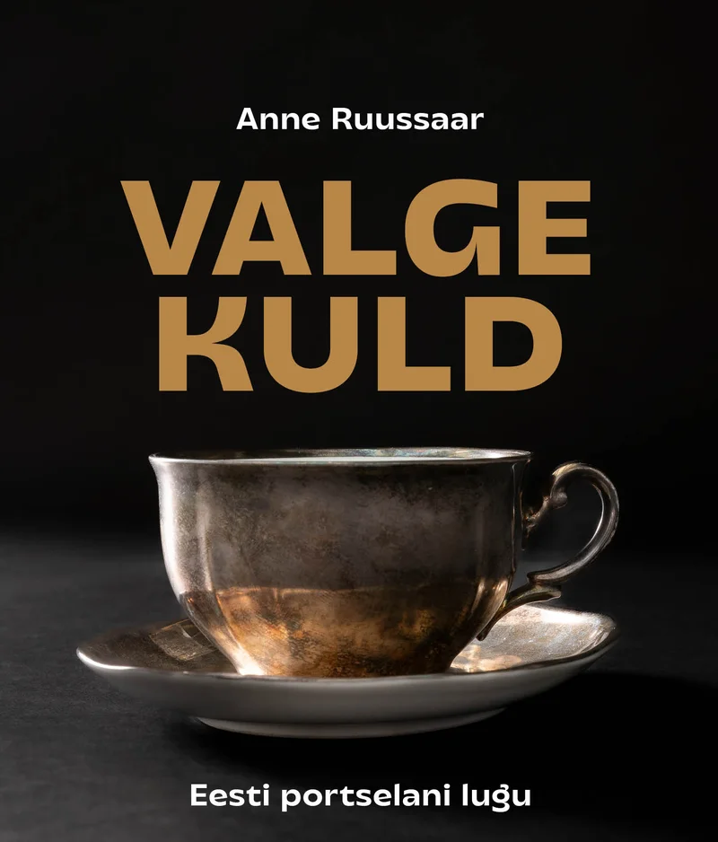 Valge Kuld - Anne Ruussaar (Hea Lugu, 2026). Tumeda taustaga kaanel on elegantne hõbedane kohvitass alustassiga, mis on fotografeeritud lähivaates dramaatilise valgusega. Klassikaline ja ajatu stiil rõhutab portselani ajaloolist väärtust ja rafineeritust.
